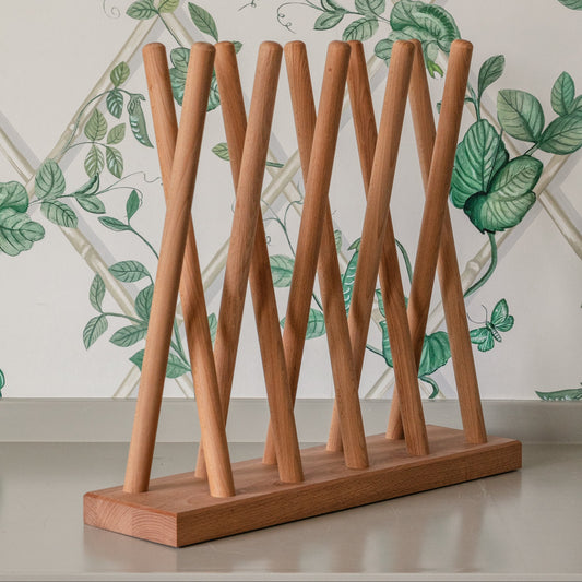 Wooden boot rack against a decorative tiled wall with green leaf patterns