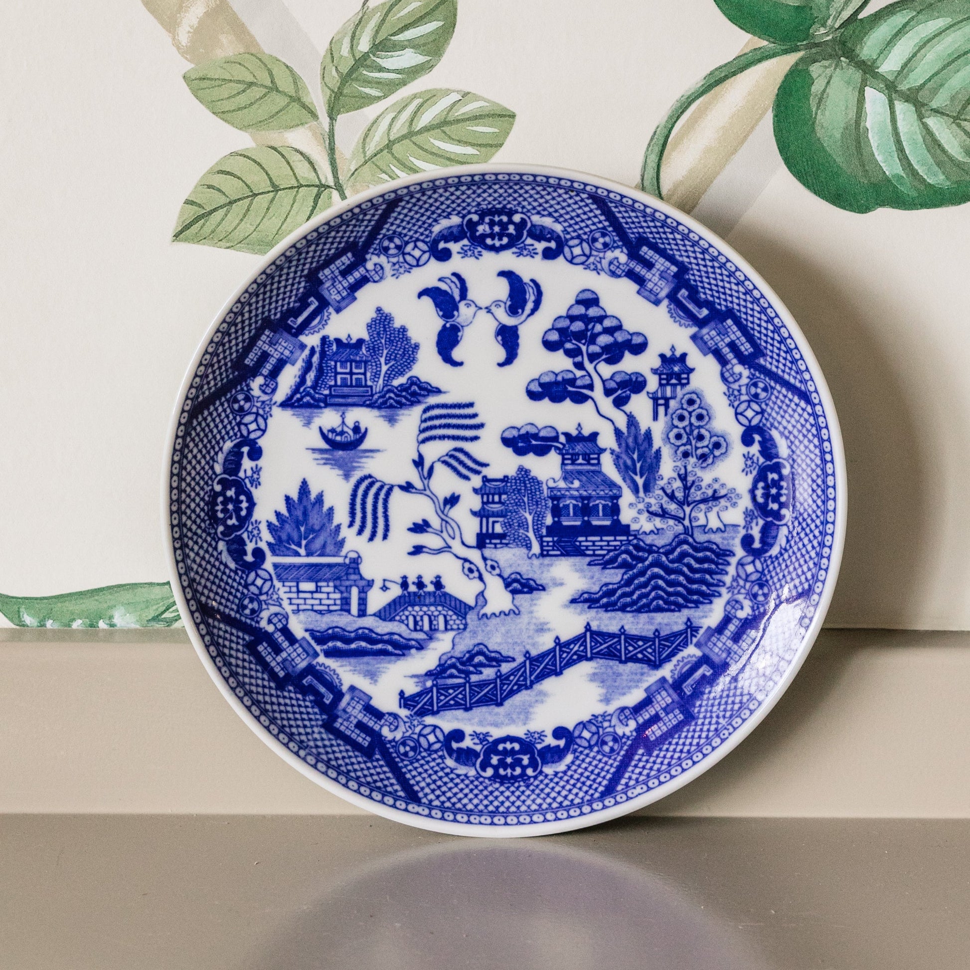 Blue and white decorative plate with intricate patterns on a neutral background
