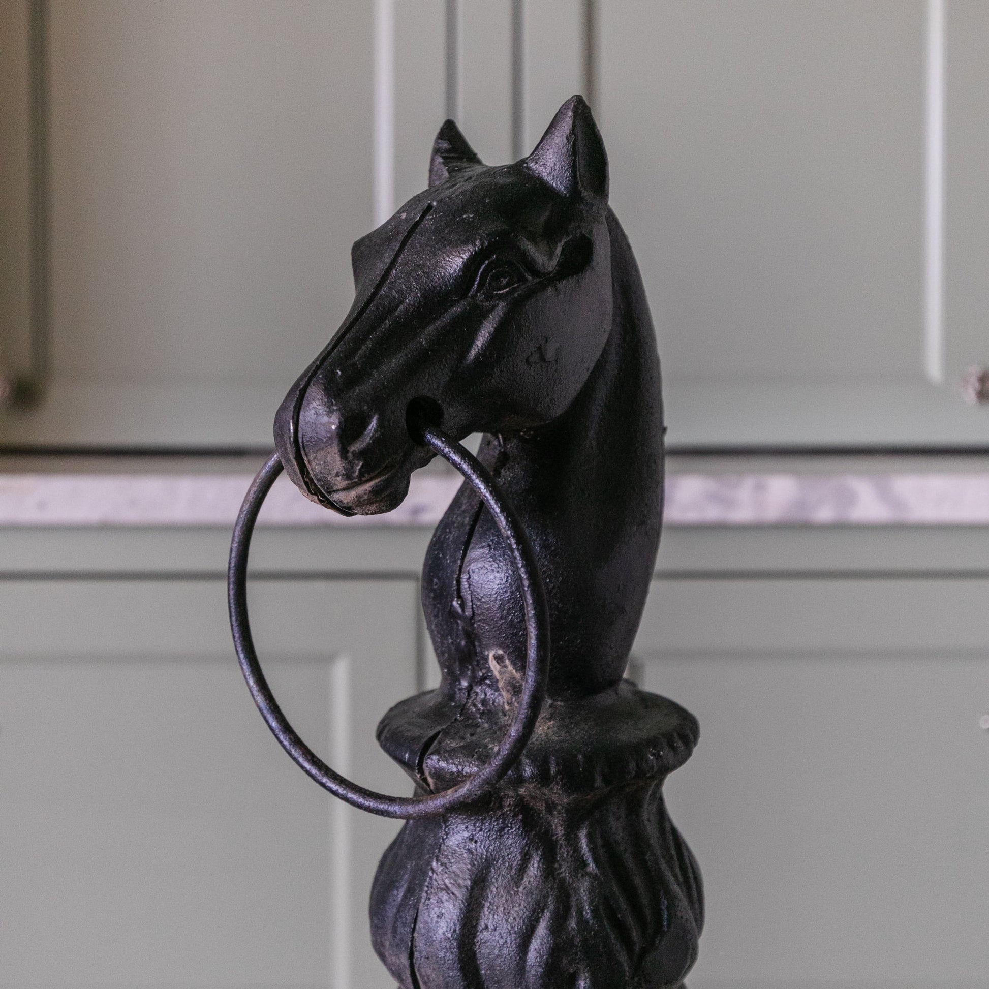 Decorative metal horse head with a ring on a white background