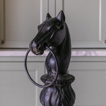 Decorative metal horse head with a ring on a white background