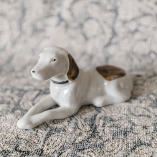 Porcelain dog figurine on a textured surface