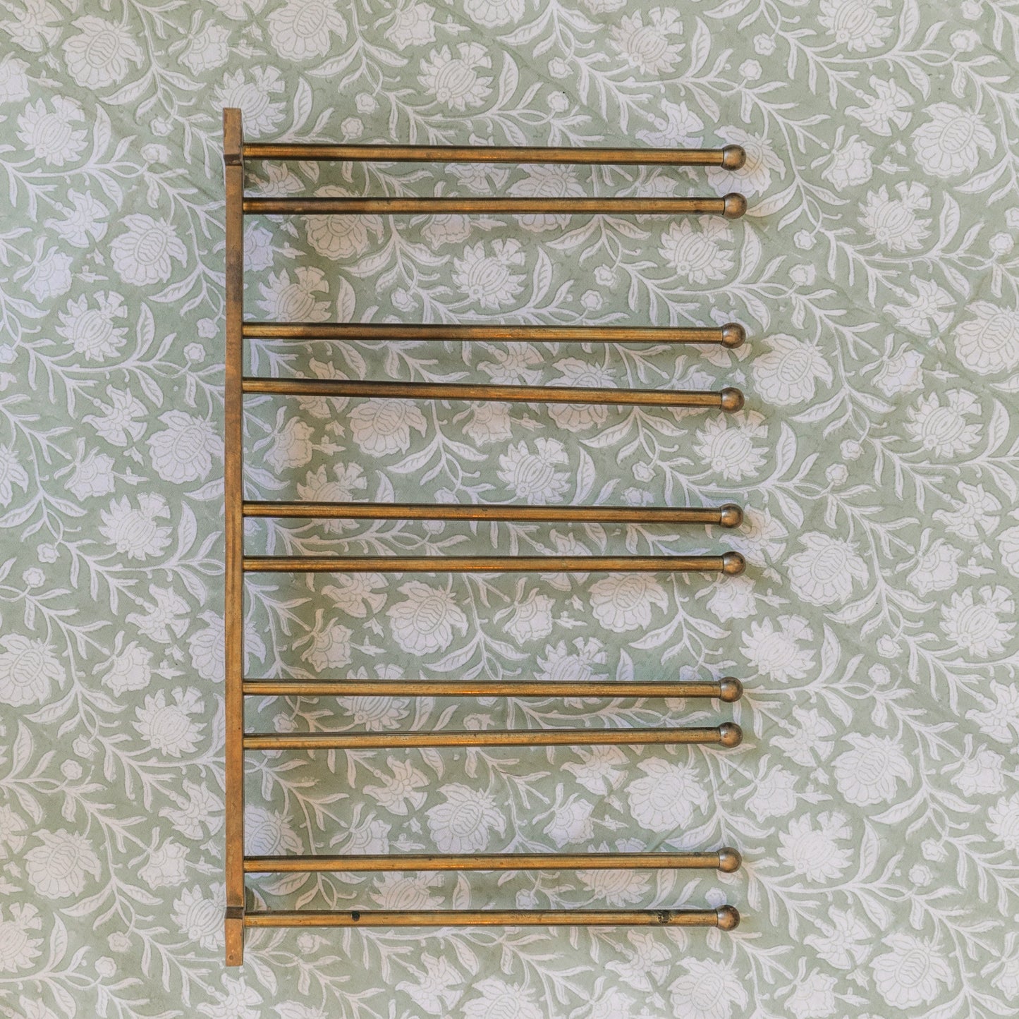 Towel rack on a floral wallpapered wall