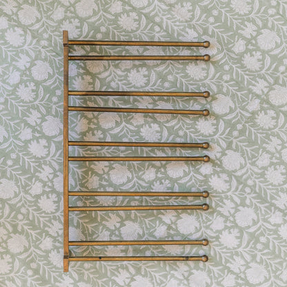 Towel rack on a floral wallpapered wall