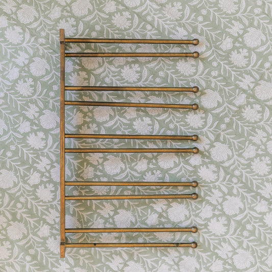 Towel rack on a floral wallpapered wall