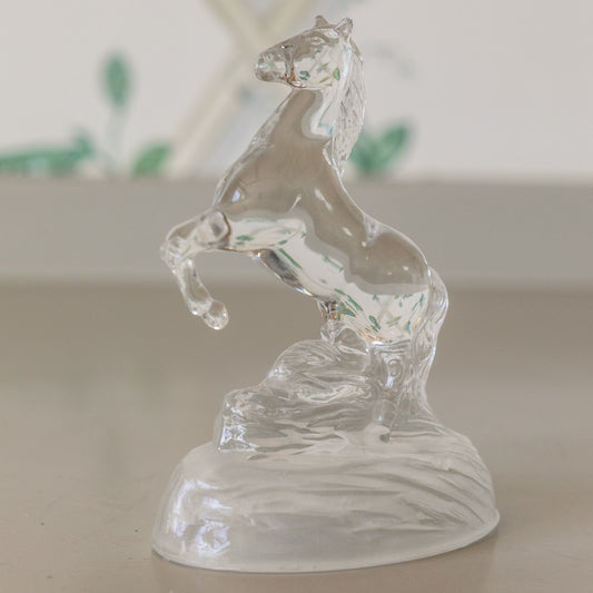 Clear glass horse figurine on a plain background
