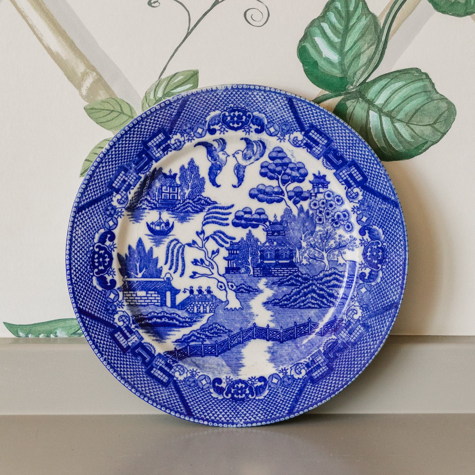 Blue and white decorative plate with intricate patterns on a neutral background