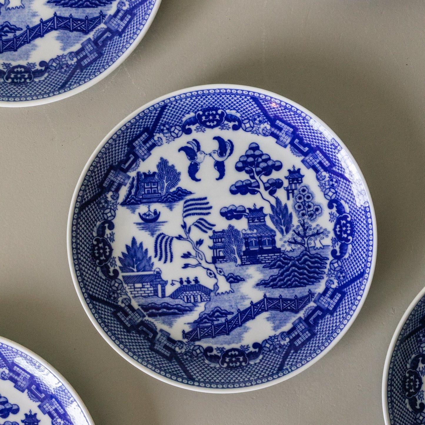 Blue and white ceramic plates with intricate patterns on a gray surface